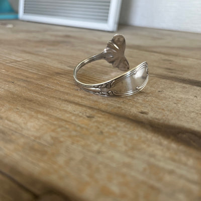 Close-up detail of Tudor pattern spoon cuff bracelet showing Art Nouveau botanical flourishes and vintage silverplate