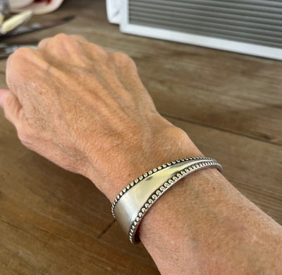 Vesta pattern spoon cuff bracelet with beaded edges shown on wrist - handcrafted from upcycled vintage silverware - Laughing Frog Studio
