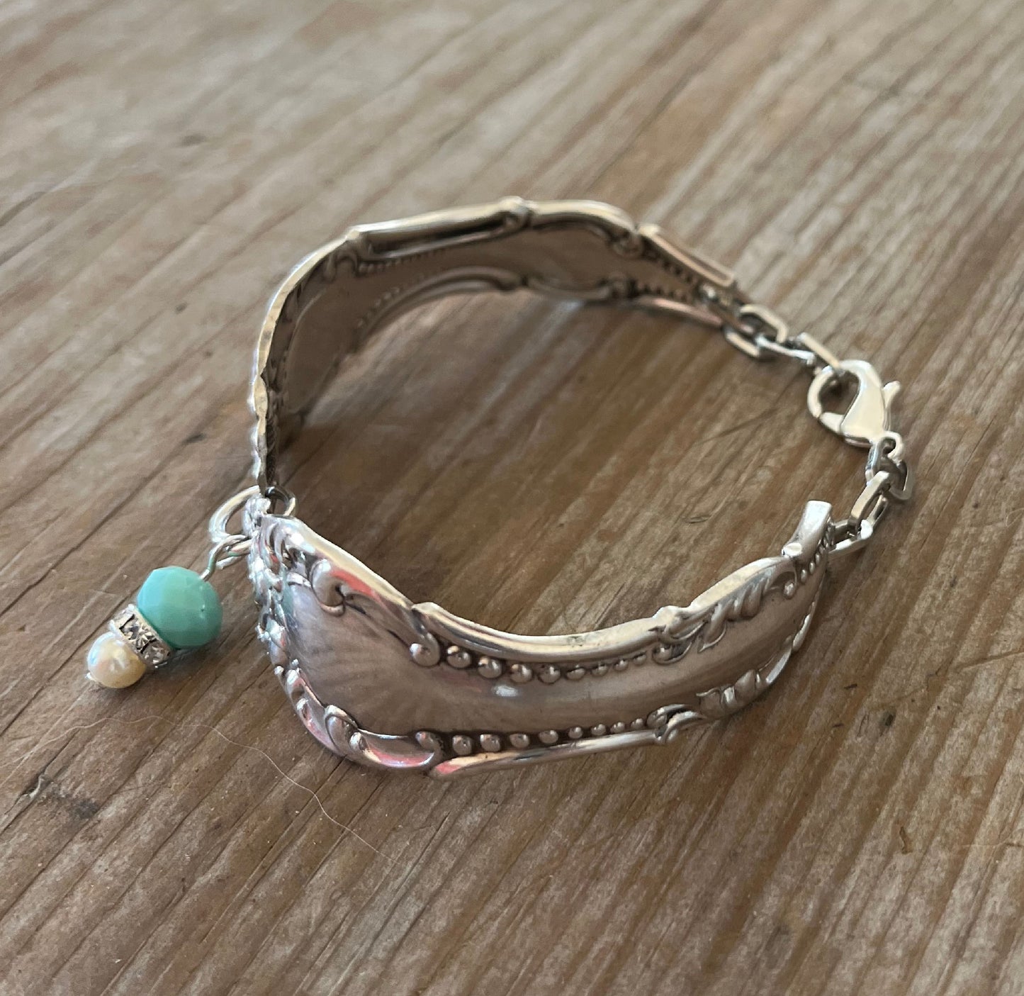 Top view of upcycled spoon bracelet with jadeite and rhinestone beads