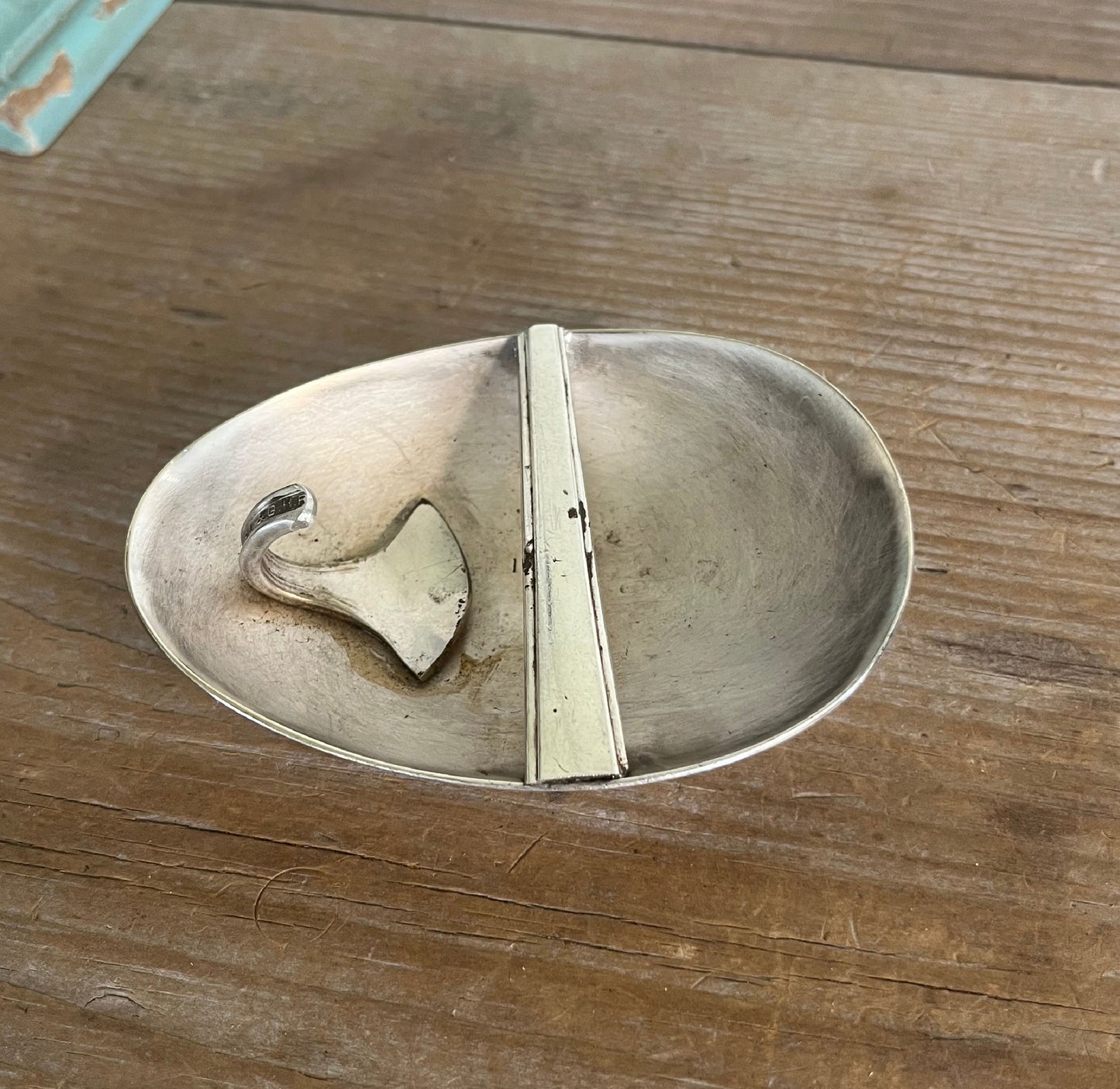 Back view of PEACE spoon belt buckle showing handcrafted catch and prongs fashioned from upcycled silverware scraps for snap belt
