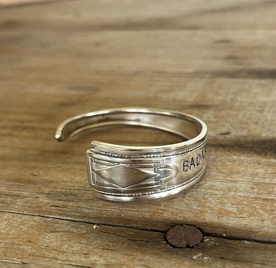 Close-up detail of BADASS hand-stamped spoon cuff bracelet showing Art Deco stepped edges and vintage silverplate