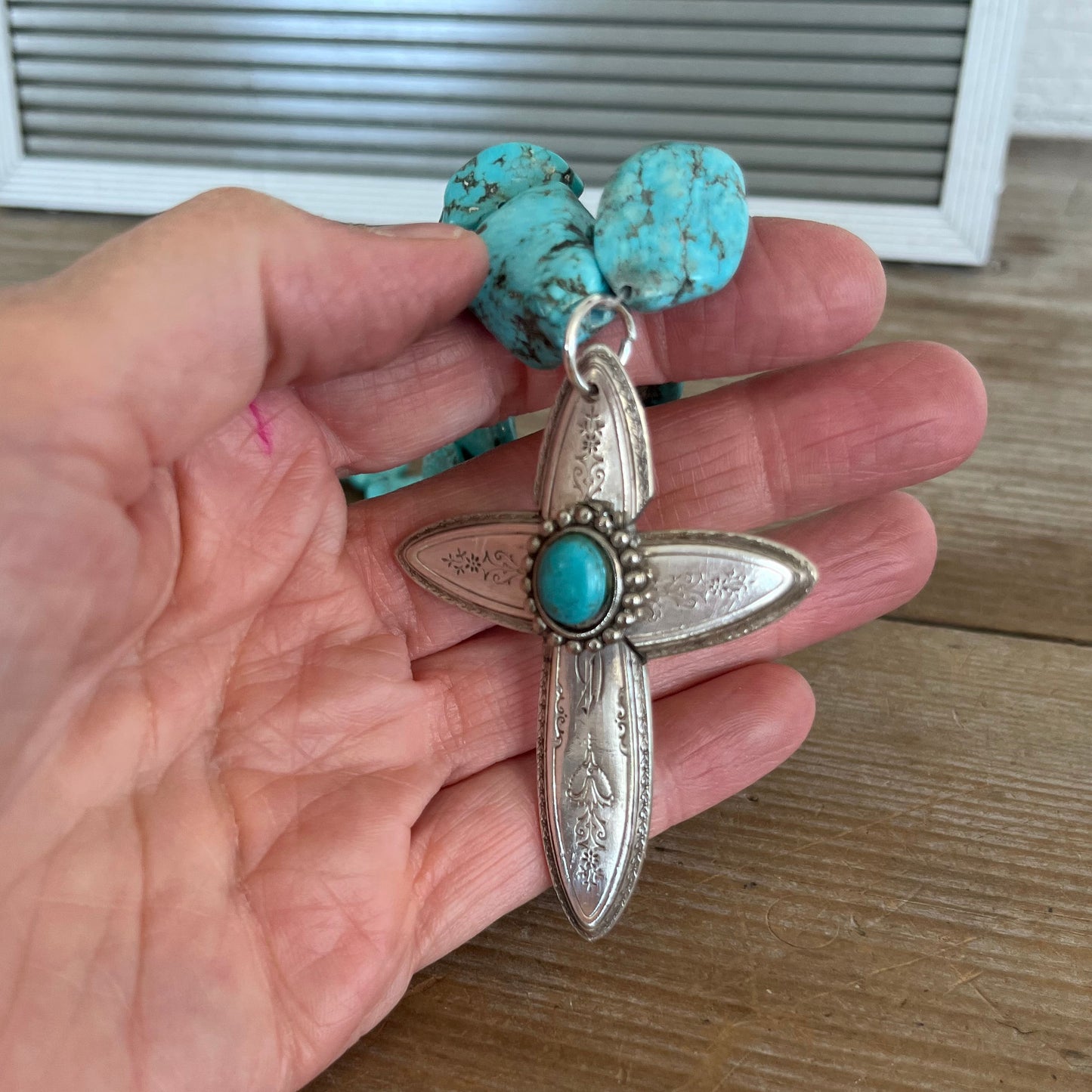Handcrafted spoon cross pendant on chunky turquoise howlite choker necklace shown in hand for size- upcycled from vintage Argosy silverware - Laughing Frog Studio