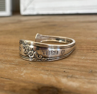 Hand-stamped spoon cuff bracelet Close-up detail of LET THEM ♥ hand-stamped spoon cuff bracelet showing floral pattern and vintage silverplate