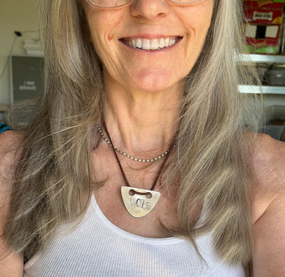 VOTE hand-stamped vintage spoon necklace worn on model showing pendant length and fit at neckline with faux suede cord - upcycled silverware spoon necklace - handcrafted from upcycled vintage silverware - Laughing Frog Studio