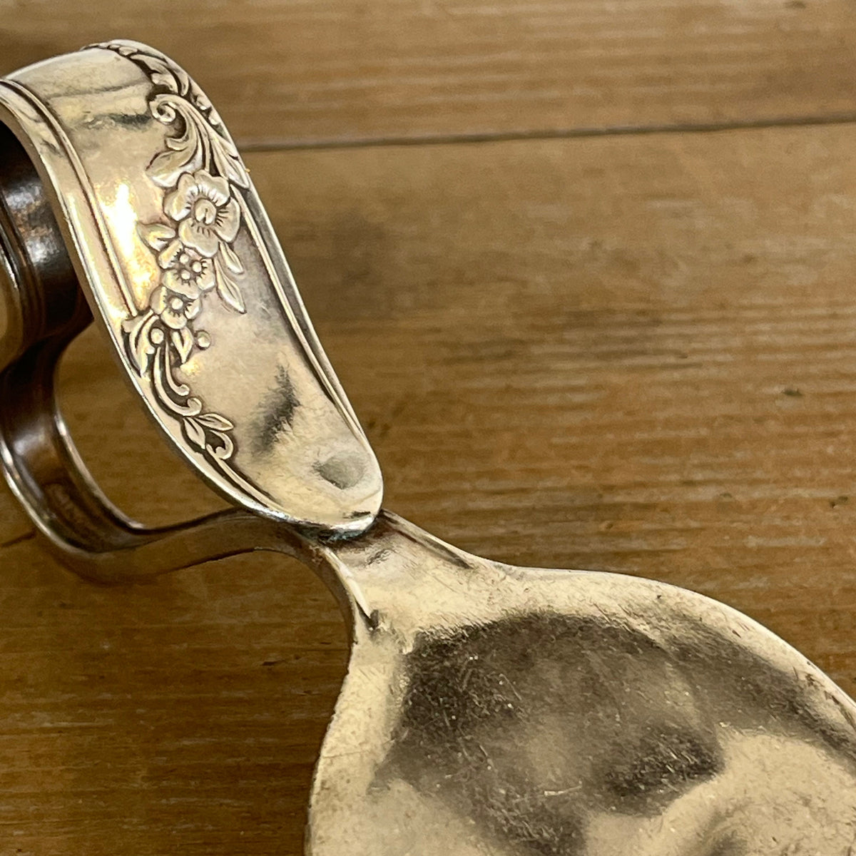 Close-up of Queen Bess II floral pattern detail on ergonomic heart handle cheese knife - handcrafted from upcycled vintage silverware - Laughing Frog Studio