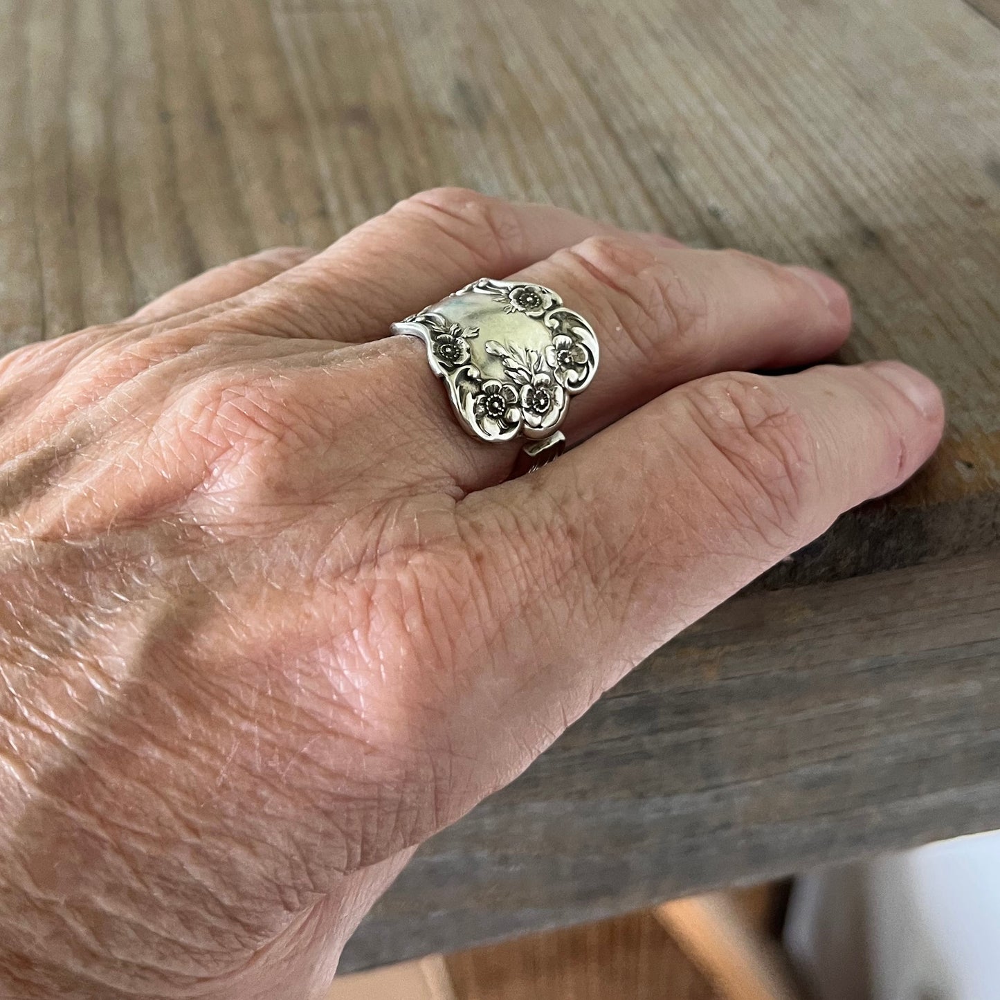 Vintage Buttercup sterling spoon ring displaying 1899 pattern craftsmanship shown on model
