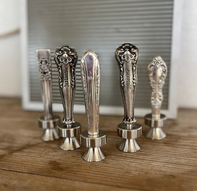 Collection of vintage knife handle bottle openers on wood surface - handcrafted from upcycled vintage silverware - Laughing Frog Studio