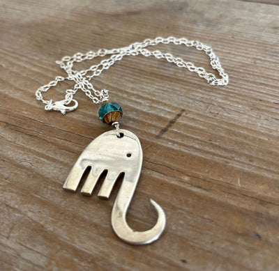 Close-up detail of handcrafted fork elephant pendant with aqua Czech glass bead, one-of-a-kind design