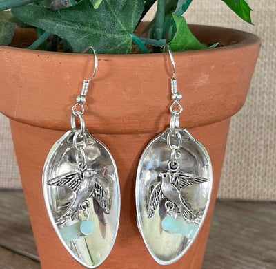 Close-up detail of spoon bowl earrings with hanging bird charm and faceted jadeite bead, 2.375 inches long - Spoon Earrings - handcrafted from upcycled vintage silverware - Laughing Frog Studio