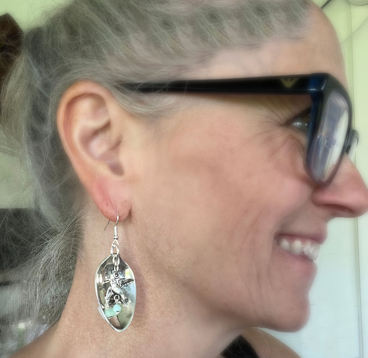 Upcycled demitasse spoon earrings with peace bird and jadeite glass accents shown on model - Spoon Earrings - handcrafted from upcycled vintage silverware - Laughing Frog Studio