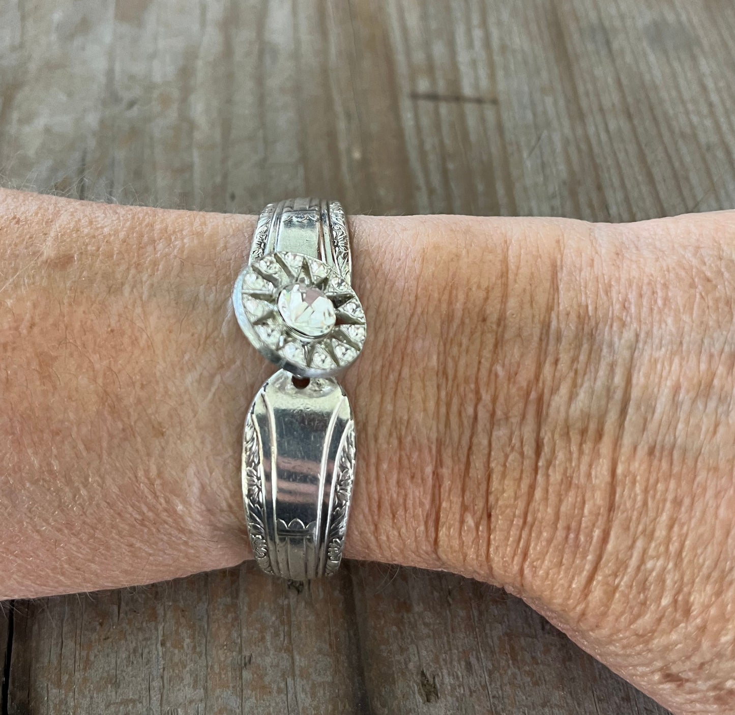 Regent spoon link bracelet with rhinestone button modeled on wrist - handcrafted upcycled artisan silverware jewelry