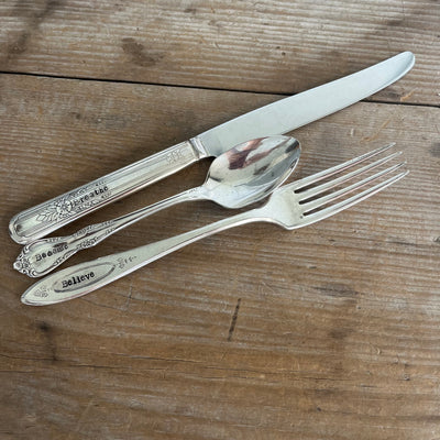Vintage hand-stamped custom silverplate flatware set with knife, fork and spoon flat lay on wood - vintage silverware - handcrafted from upcycled vintage silverware - Laughing Frog Studio