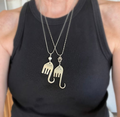 Two fork elephant necklaces worn together on model showing Hamsa and pearl bead styles layered - handcrafted from upcycled vintage silverware - Laughing Frog Studio