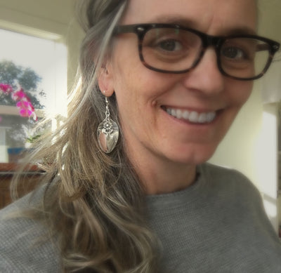 Demitasse spoon earrings with flower charm shown on model