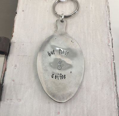 Close-up of But First Coffee hand-stamped spoon keychain showing vintage silverware detail and lettering