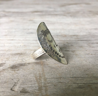 Side view of Women of Nature Celeste spoon ring showing hand-stamped woman's face and striped flower shank detail