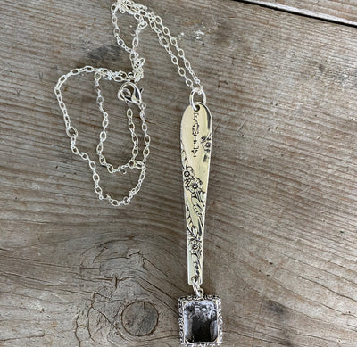Close-up of FAMILY hand-stamped vintage silverware handle pendant showing Bridal Wreath pattern detail and swappable photo insert