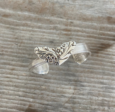 Close-up of soldered heart detail on vintage spoon cuff bracelet showing Evening Star pattern