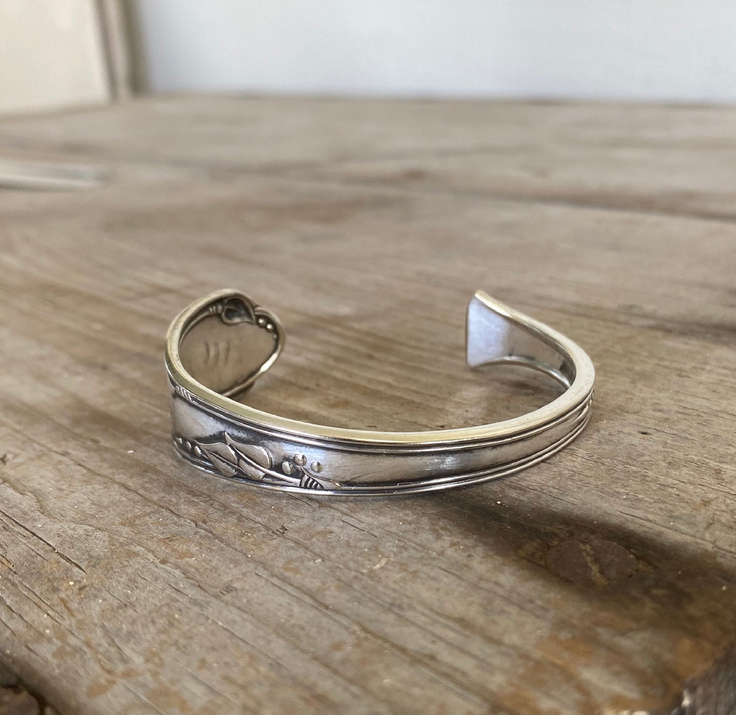 Close-up detail of Meadowbrook/Heather floral pattern on FREE SPIRIT hand-stamped spoon cuff bracelet