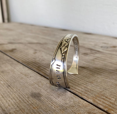 Close-up detail of FREE SPIRIT hand-stamped spoon cuff bracelet showing Meadowbrook/Heather floral pattern and vintage silverplate