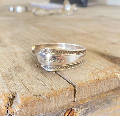 Close-up detail of REMEMBER hand-stamped spoon cuff bracelet showing Croydon/Mary Lee pattern and vintage silverplate