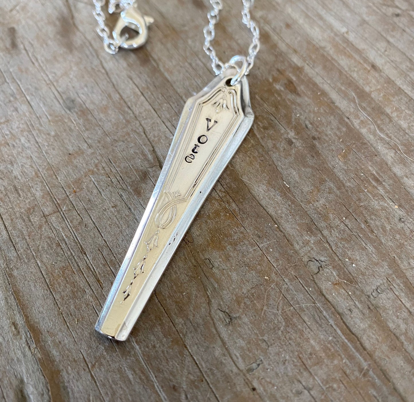 Close-up detail of VOTE bar pendant showing hand-stamped lettering on vintage 1923 Duchess pattern silverware, minimalist design, 18-inch chain