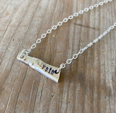 Close-up detail of VOTE bar pendant showing hand-stamped lettering on vintage silverware, 1.25 inches wide