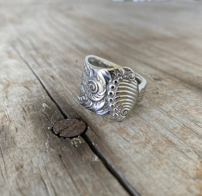 Close-up of MILANO pattern spoon ring showing ornate vintage silverware detail