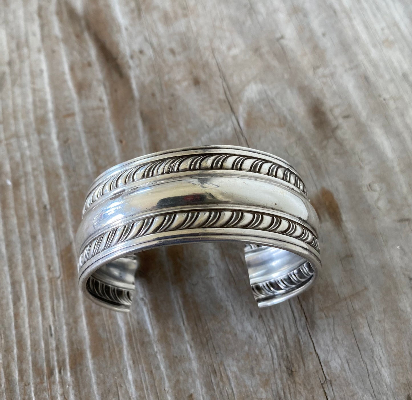 Detail of feathery border and curved raised lines on vintage Weidlich sterling silver napkin ring cuff