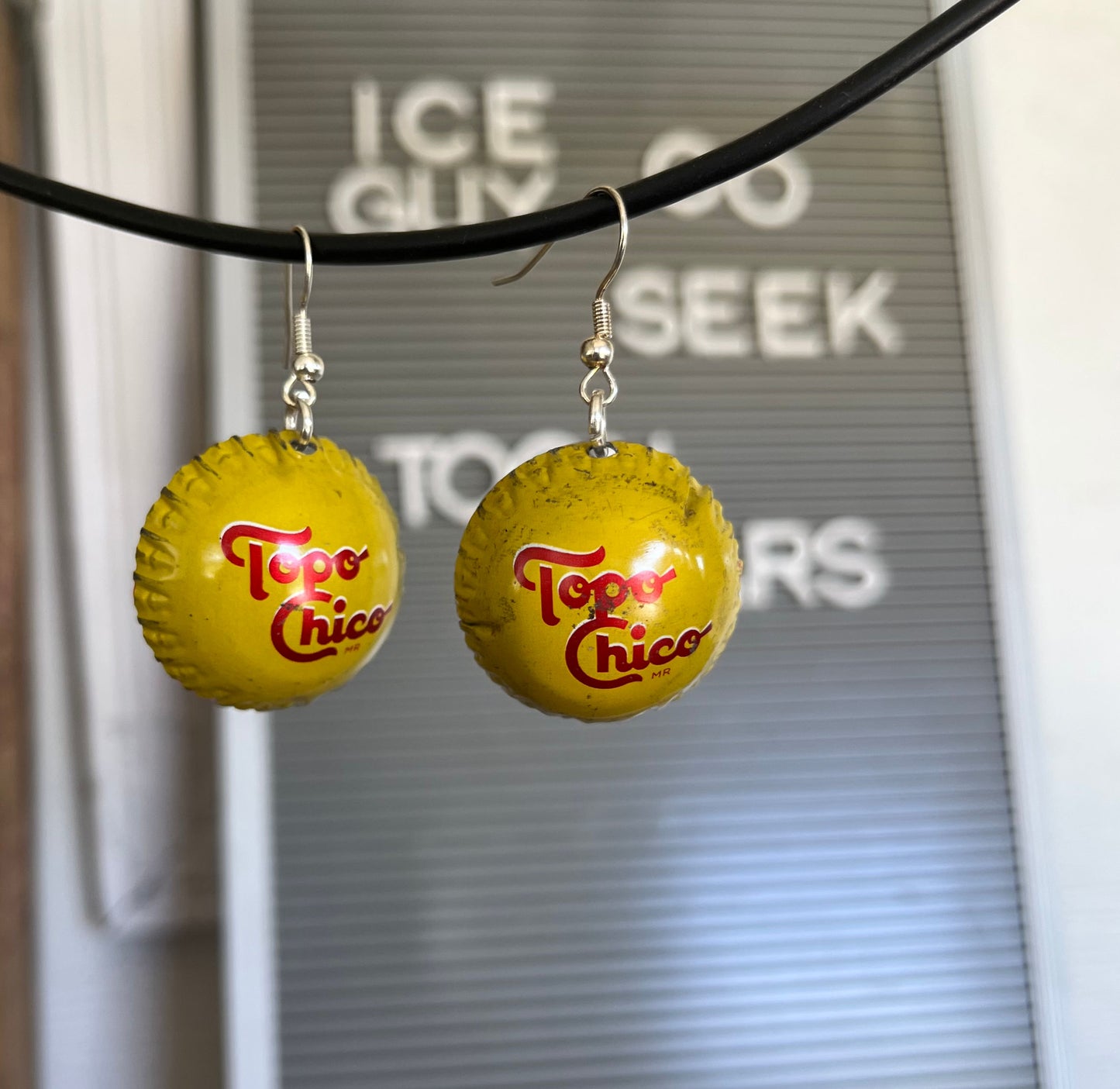 Upcycled Topo Chico bottle cap earrings displaying bright cheerful colors and handcrafted wearable design