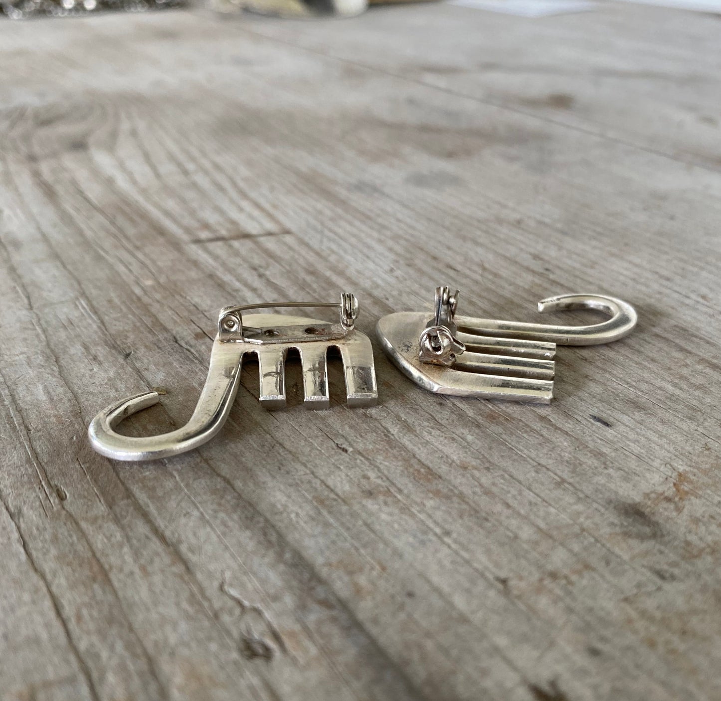 Detailed view of elephant pin showing stainless steel safety-catch pin closure on upcycled fork jewelry