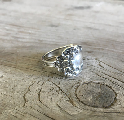 Close-up of intricate curly-q flourishes and paisley design on sterling silver spoon ring in crisp relief