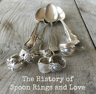 Handcrafted spoon ring resting on vintage silverware - history of spoon rings - upcycled silverware jewelry - Laughing Frog Studio