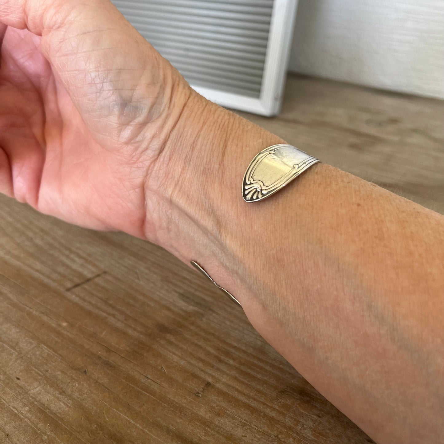 Tudor spoon cuff bracelet shown on model wrist - vintage 1904 silverplate with flowing Art Nouveau curves