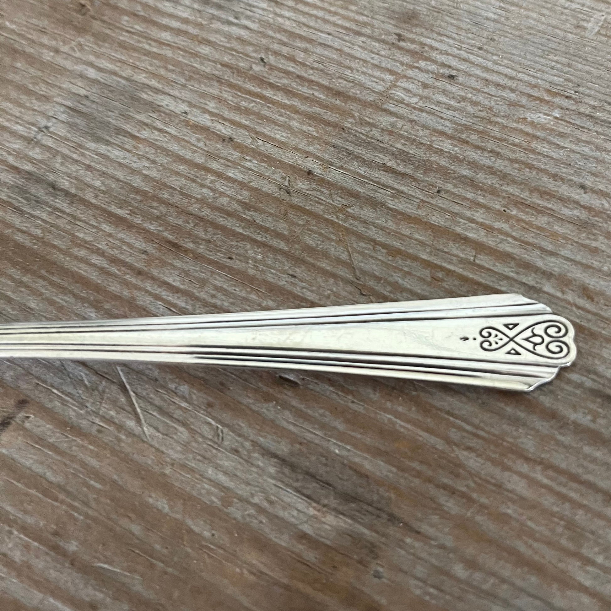 Close-up of SPREAD LOVE handle of vintage silverware spreader knife