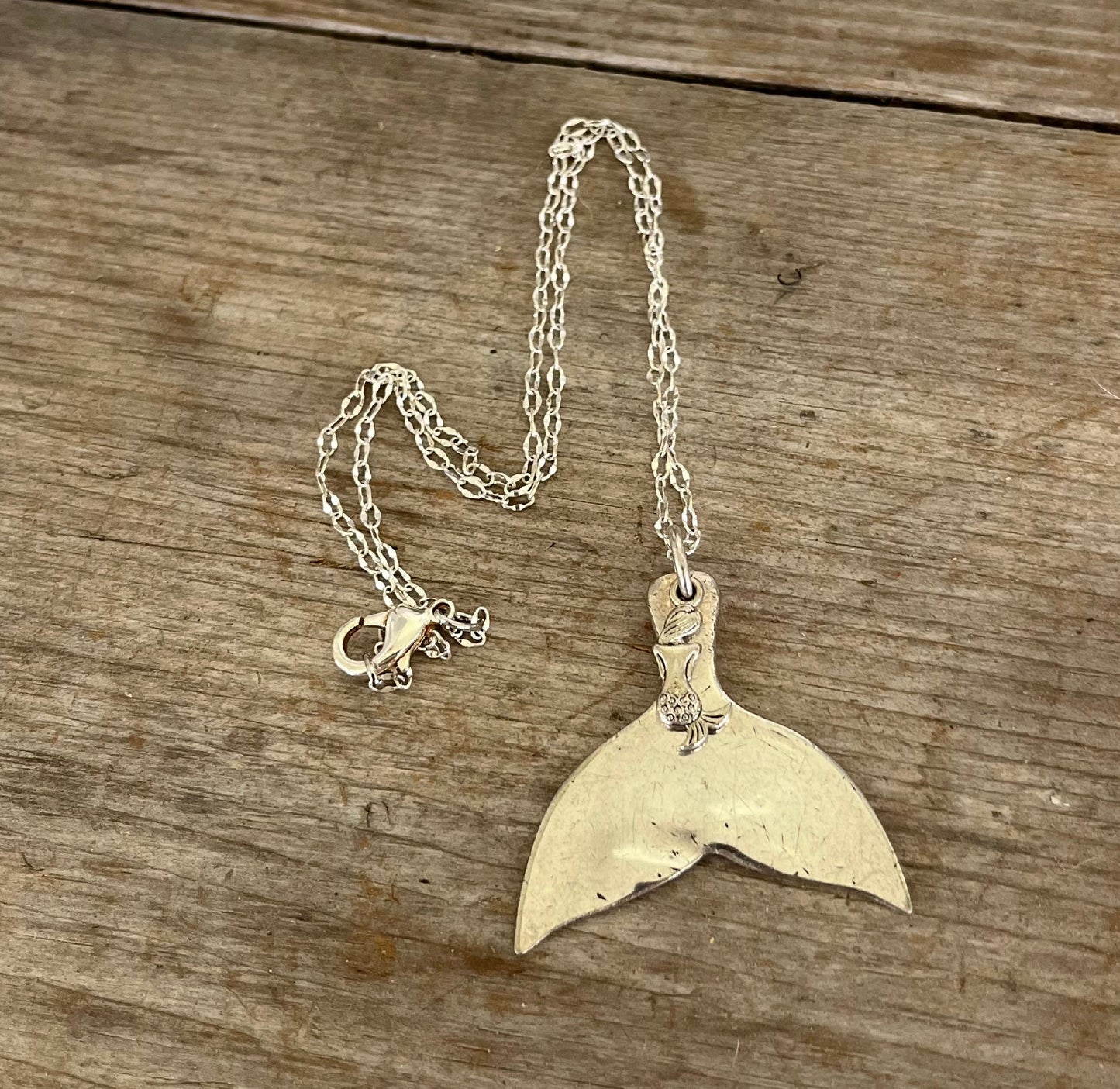 handmade spoon necklace shaped like a mermaid or whale tail