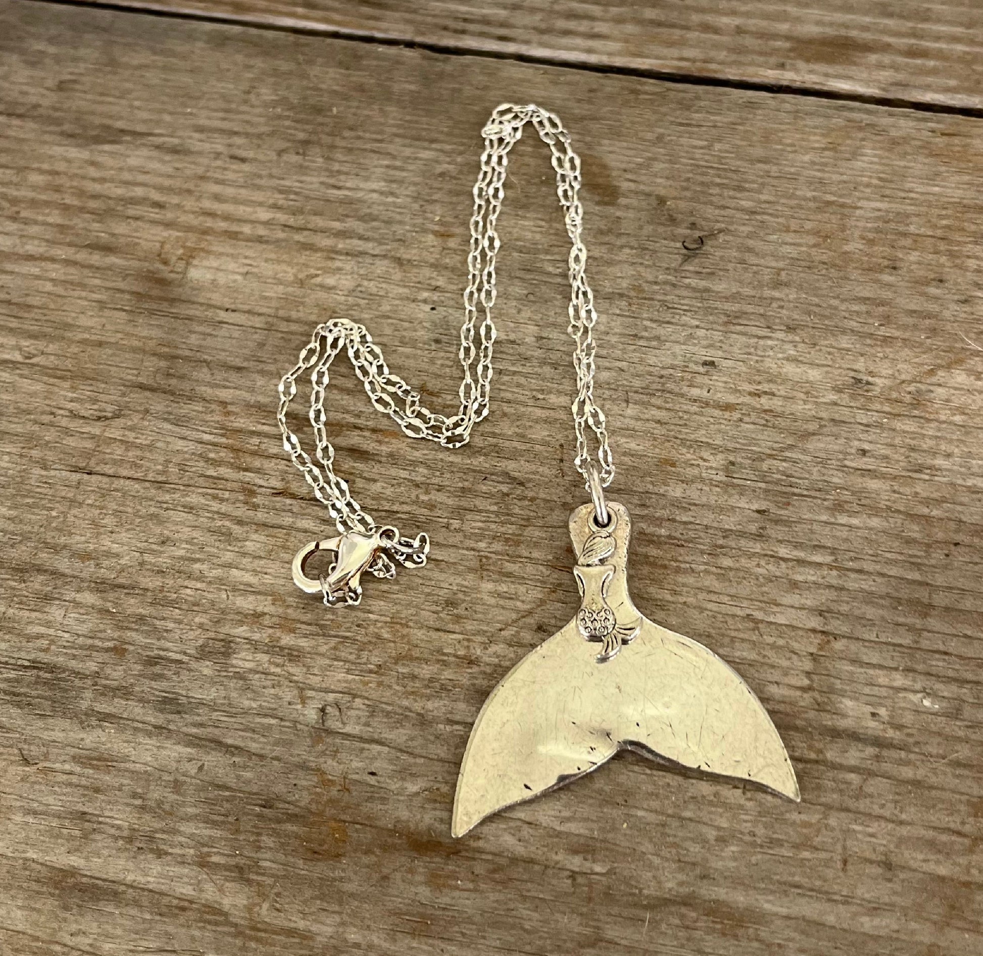 handmade spoon necklace shaped like a mermaid or whale tail