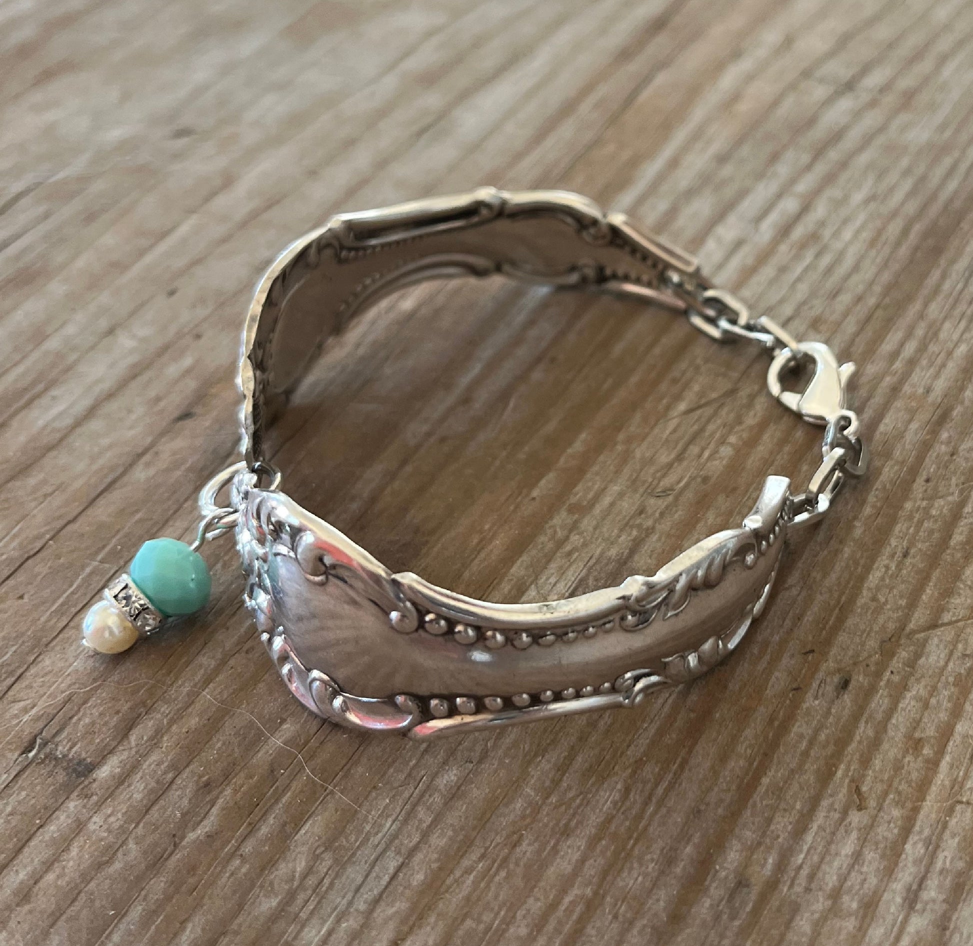 Top view of upcycled spoon bracelet with jadeite and rhinestone beads