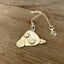 Close-up of hand-cut and hand-stamped puppy face pendant made from patchwork vintage spoon bowls, artisan silverware jewelry