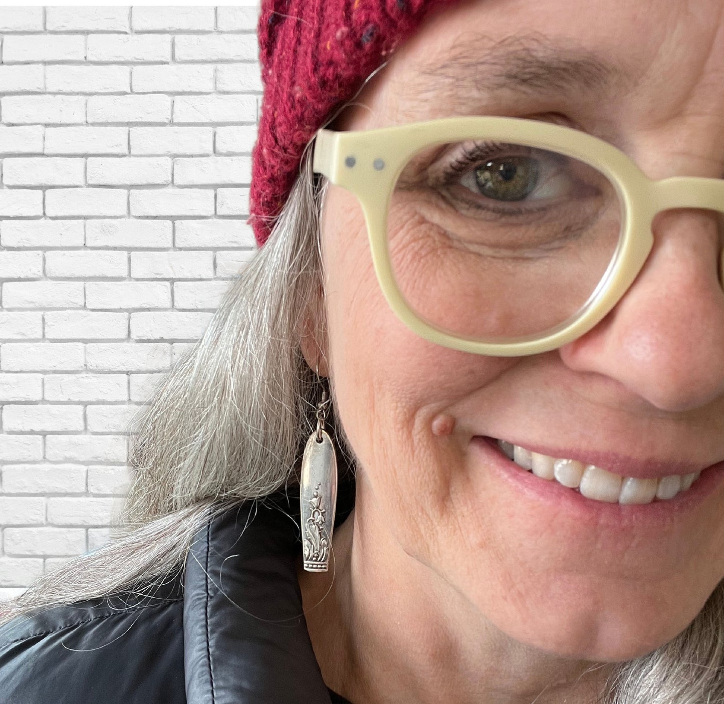 Snow Drop spoon earrings modeled on ear showing wearable fit and delicate floral detail, 2.625 inches long