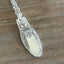 Close up of 1847 Rogers First Love pattern spoon pendant necklace - handcrafted from upcycled vintage silverware - Laughing Frog Studio