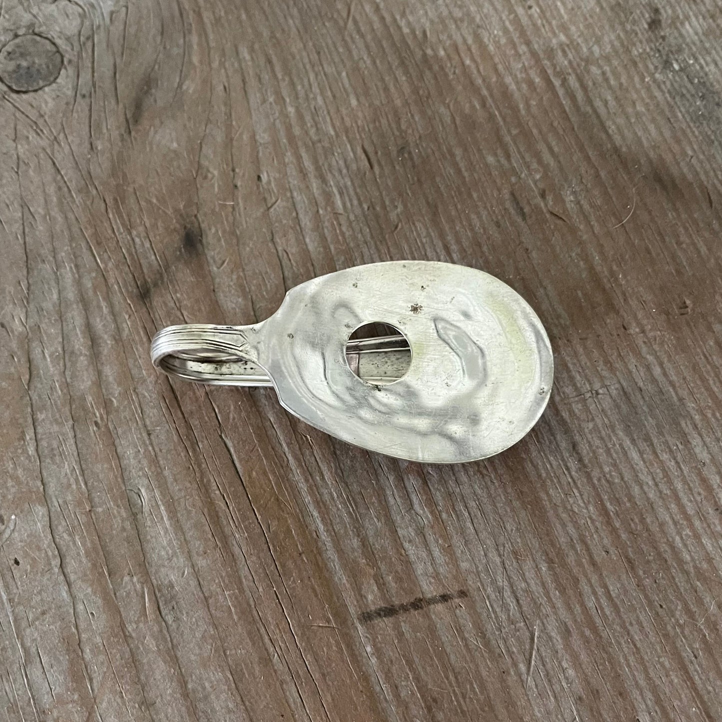 Close-up of guitar money clip showing upcycled vintage silverware spoon Art Deco Moderne pattern and sound hole