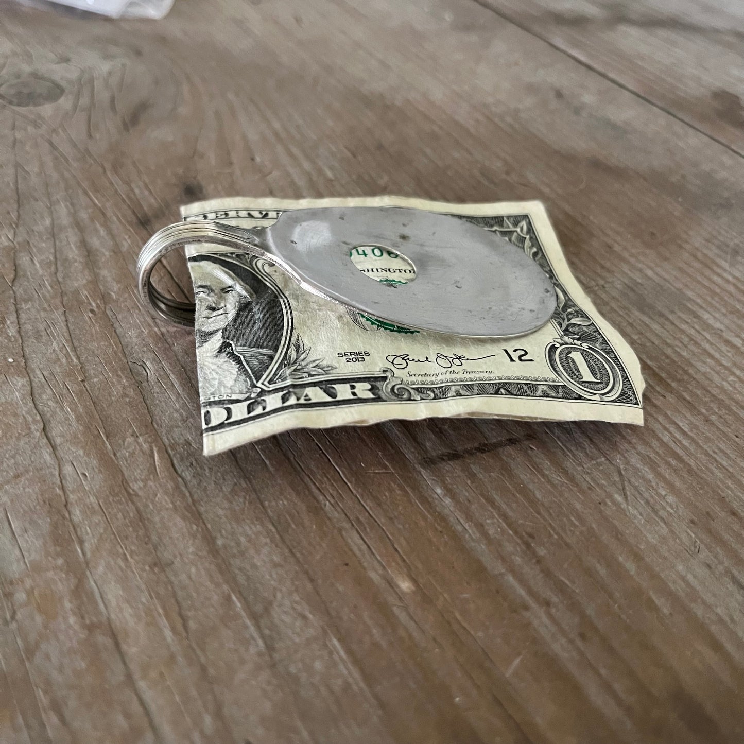 Side view of guitar money clip showing upcycled vintage silverware spoon with bent neck and clip mechanism