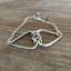 Close-up detail of fork tine heart charm on relationship bracelet - handcrafted upcycled silverware artisan jewelry