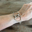 Fork tine heart relationship bracelet modeled on wrist - handcrafted upcycled vintage silverware artisan jewelry gift