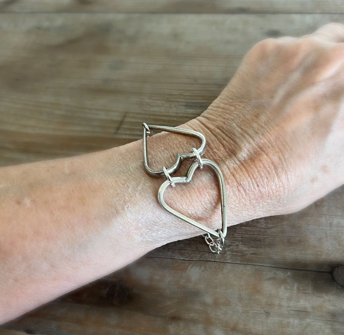 Fork tine heart relationship bracelet modeled on wrist - handcrafted upcycled vintage silverware artisan jewelry gift