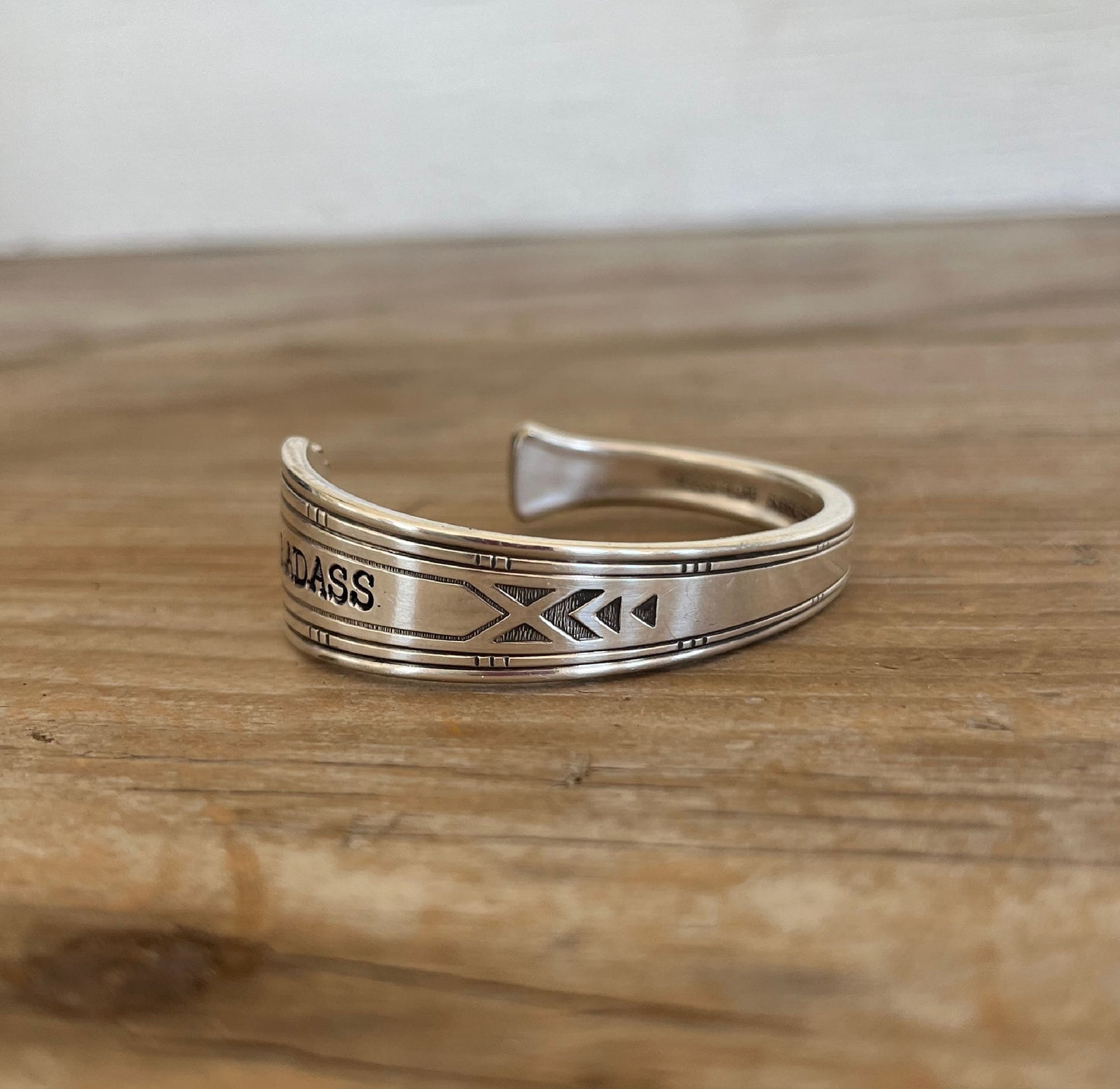 BADASS stamped spoon cuff bracelet flat lay showing Friendship/Medality pattern detail - handcrafted from upcycled vintage silverware