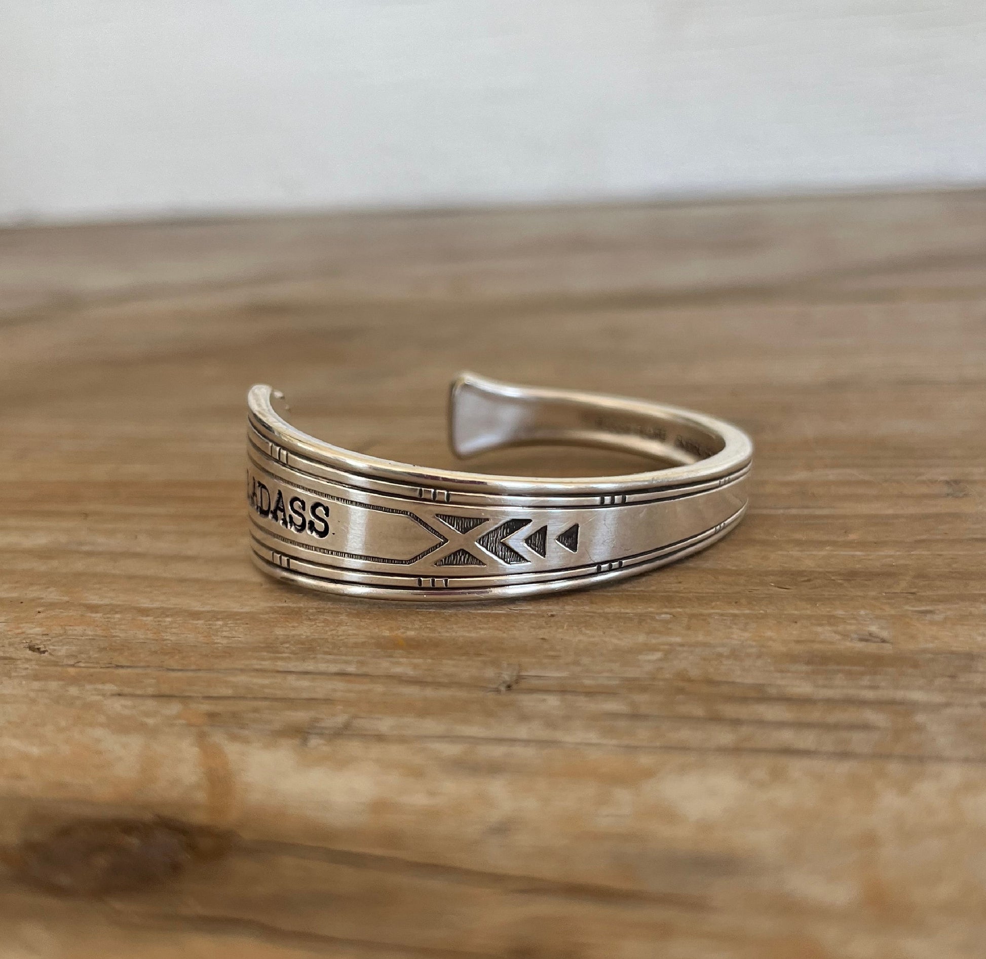 BADASS stamped spoon cuff bracelet flat lay showing Friendship/Medality pattern detail - handcrafted from upcycled vintage silverware