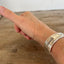 BADASS hand-stamped spoon cuff bracelet side angle on wrist - vintage 1932 Tudor Plate silverplate with empowering message