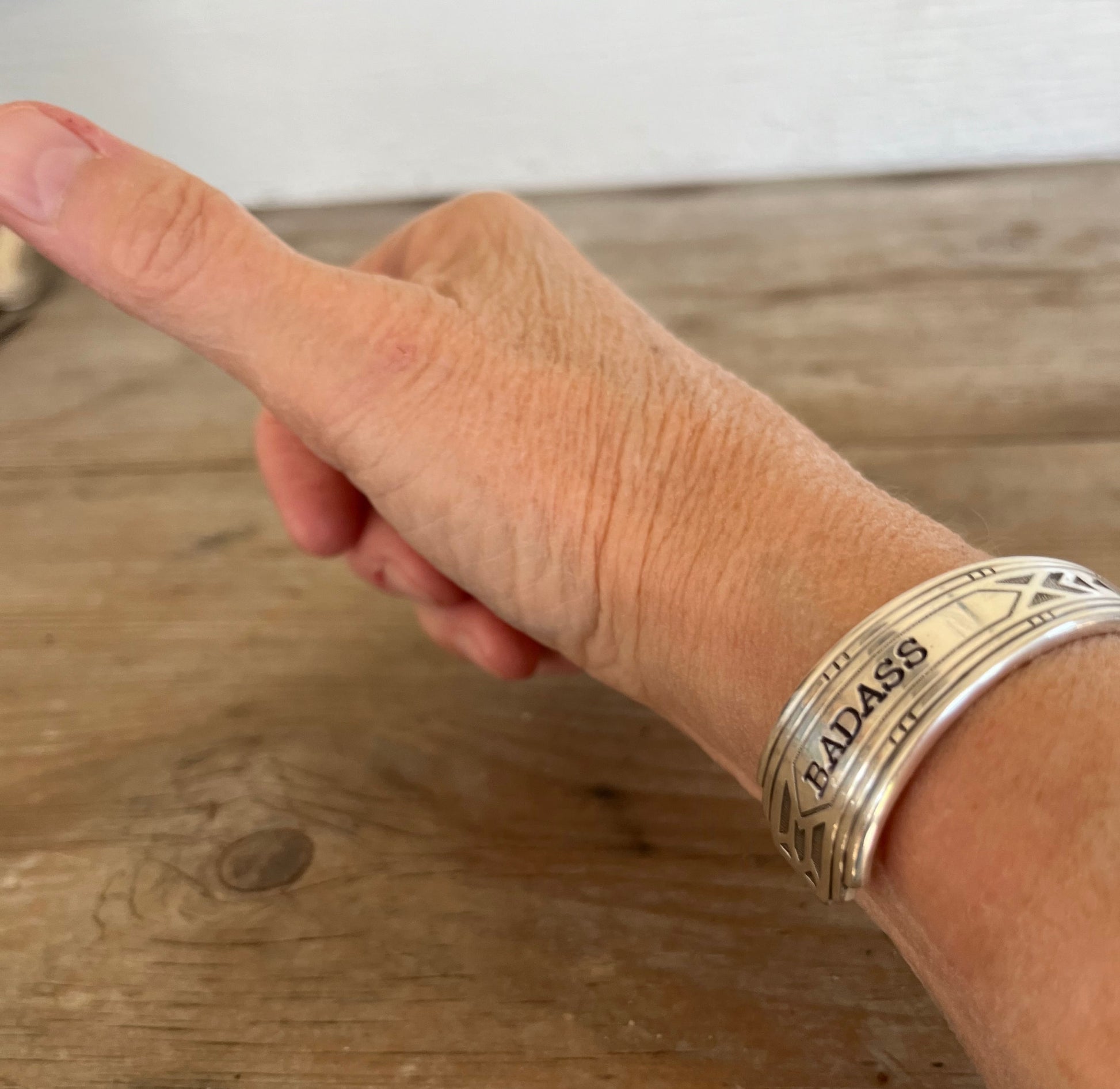 BADASS hand-stamped spoon cuff bracelet side angle on wrist - vintage 1932 Tudor Plate silverplate with empowering message